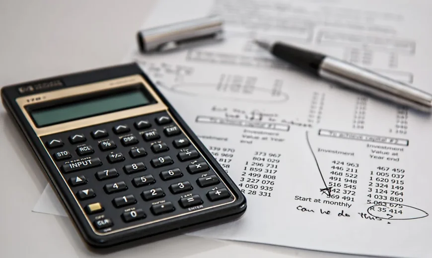 Calculator on financial documents representing logo design cost across pricing tiers in 2026