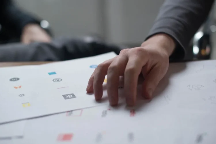 Hand reviewing different types of logos printed on paper